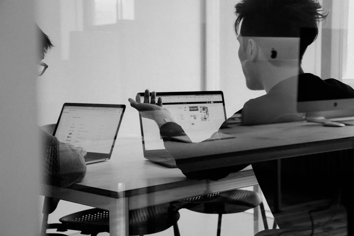 Two colleagues collaborating on laptops